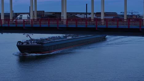 As-darkness-falls-tanker-ship-the-En-Avant-sailing-under-the-Noord-River-Bridge