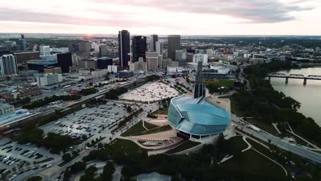 Ein-Zoom-In-Den-Sonnenuntergang,-Goldene-Stunde,-Luftaufnahme-Des-Stadtparks,-Kanadisches-Museum-Für-Menschenrechte,-The-Forks-Market,-Innenstadt-Von-Winnipeg,-Shaw-Park,-Provencher-Bridge,-Red-River-In-Manitoba,-Kanada