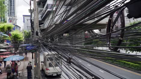 Oberleitungen,-Kabel-Und-Stromleitungen-Bilden-Einen-Unordentlichen-Schandfleck-über-Den-Straßen-Von-Bangkok,-Thailand