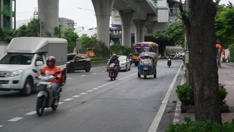 Tuk-Tuk,-Motorbike-Taxis,-And-City-Bus-Traveling-In-Downtown-Bangkok,-Thailand