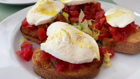 Classic-traditional-Italian-bruschetta-bread-with-tomatoes,-mozzarella-cheese-and-olive-oil,-tasty-food,-4K-shot