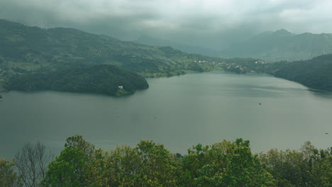 Drone-shot-viewing-Begnas-Lake-Pokhara-,-Nepal-landscape-with-trees-and-lakes,-blue-sky,-clouds,-and-touristy-nature