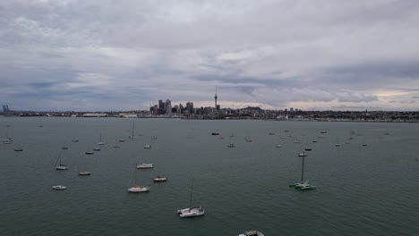 Luftaufnahmen-über-Dem-Hafen-Von-Waitemata-Mit-Der-Skyline-Der-Stadt-Auckland-In-Neuseeland-Mit-Yachten-Im-Vordergrund