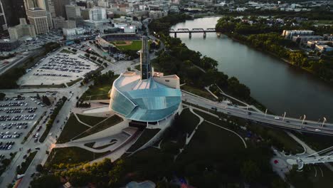 A-Fly-Over-Sunset-Golden-Hour-Aerial-View-of-the-Urban-Park-Canadian-Museum-for-Human-Rights-The-Forks-Market-Downtown-Winnipeg-Shaw-Park-Provencher-Bridge-Red-River-in-Manitoba-Canada