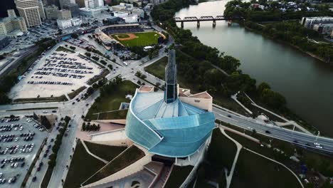 A-Reveal-Sunset-Golden-Hour-Aerial-View-of-the-Urban-Park-Canadian-Museum-for-Human-Rights-The-Forks-Market-Downtown-Winnipeg-Shaw-Park-Provencher-Bridge-Red-River-in-Manitoba-Canada