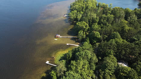 Bird's-eye-view-of-green-lake-shore-water-and-private-docks-with-vibrant-green-trees