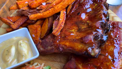 Classic-bbq-pork-ribs-with-sweet-potato-fries-and-coleslaw,-tasty-meal,-4K-shot