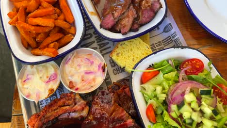 Beef-brisket-with-salad,-pork-ribs-with-sweet-potato-fries,-cornbread-and-coleslaw,-traditional-american-food,-big-family-meal,-4K-shot