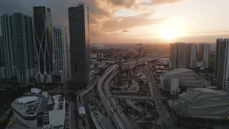 Aerial-Drone-Fly-Above-Golden-Sunset-Horizon-Skyline-Background-in-Miami-Downtown-Skyscraper-Urban-Square,-United-States-Florida-Establishing-Shot