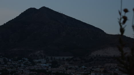 Puesta-De-Sol-Sobre-Un-Pueblo-Con-Montañas-Al-Fondo,-Timelapse