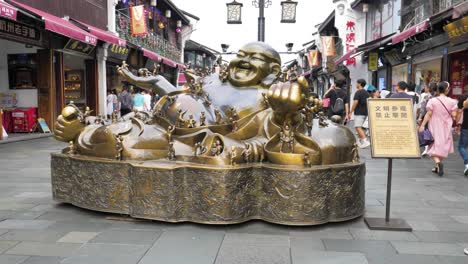 Zeitlupenaufnahme-Von-Touristen,-Die-An-Der-Goldenen-Buddha-Statue-Im-Qinghefang-Viertel-Vorbeigehen