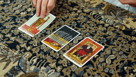 Eine-Frau-Liest-Eine-Tarot-Lesung-Mit-Der-Seite-Der-Zauberstäbe,-Der-Zehn-Der-Schwerter-Und-Den-Kaiserkarten