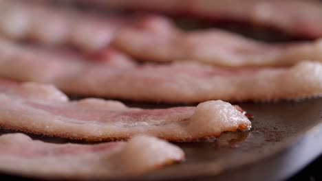 Bacon-strips-on-a-griddle-sizzle-and-lift-as-they-cook