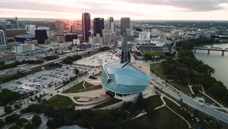 A-Sunset-Cinematic-Golden-Hour-Aerial-View-of-the-Urban-Park-Canadian-Museum-for-Human-Rights-The-Forks-Market-Downtown-Winnipeg-Shaw-Park-Provencher-Bridge-Red-River-in-Manitoba-Canada