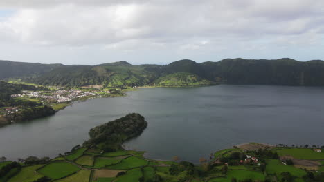 Aerial-view-traveling-in-the-lake-that-is-located-in-the-caldera-of-the-volcano-and-near-the-city-of-Sete-Cidades-in-the-Azores,-island-of-Sao-Miguel