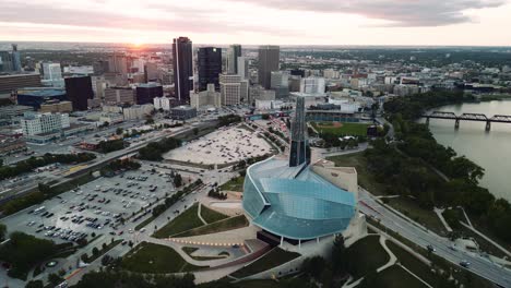 Ein-Sonnenuntergang,-Goldene-Stunde,-Luftaufnahme-Des-Stadtparks,-Kanadisches-Museum-Für-Menschenrechte,-The-Forks-Market,-Innenstadt-Von-Winnipeg,-Shaw-Park,-Provencher-Bridge,-Red-River-In-Manitoba,-Kanada