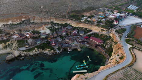 Aerial-view-around-the-Popeye-Village,-sunny-evening-in-Prajjet-Bay,-Malta
