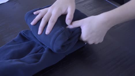 Footage-of-a-person-folding-a-sweater-into-a-small-package