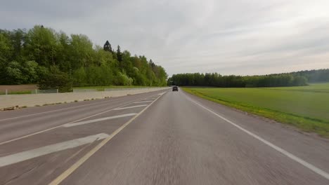 Point-of-view-perspective-of-a-car-driving-rapidly-on-a-calm-country-road