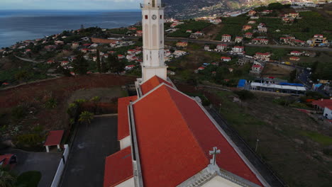 Vista-Aérea-De-La-Iglesia-De-Sao-Martinho-En-Funchal,-Madeira:-Movimiento-De-Grúa-Descendiendo-Por-La-Hermosa-Iglesia-Durante-La-Puesta-De-Sol