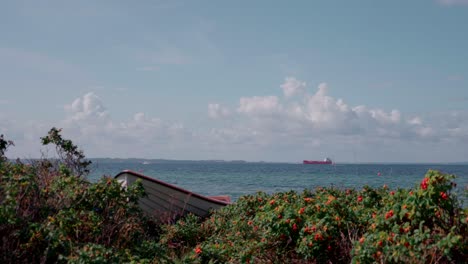 rowing-boat-on-shore-with-ship-in-the-horizont-in-slow-motion