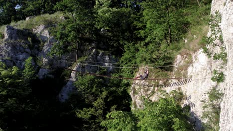 Tourist-Stürzt-Beim-Überqueren-Einer-Hängenden-Holzbrücke,-Wird-Aber-Durch-Klettersteigausrüstung-Gerettet