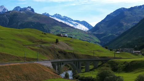 Furka-Pass-Landschaft-In-Der-Schweiz-Mit-Eisenbahnübergang,-Ziegelbrücke,-Unter-Der-Ein-Wildbach-Fließt
