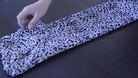Footage-of-a-woman-folding-a-t-shirt-with-a-print