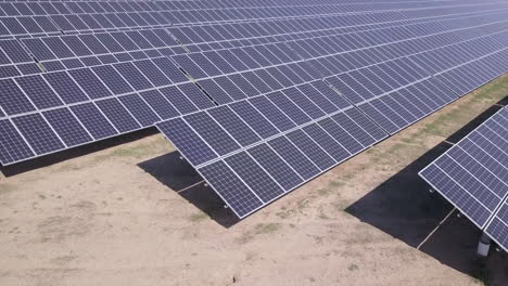 Low-rotating-aerial-view:-Solar-power-farm,-many-rows-of-solar-panels