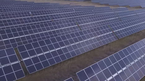 Aerial-perspective-shift-over-array-of-solar-panels-on-solar-farm