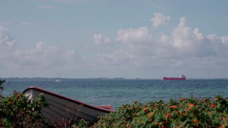 rowing-boat-on-shore-with-ship-in-the-horizont-in-slow-motion