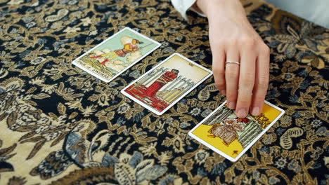 A-woman-giving-a-tarot-reading-with-the-page-of-swords-the-eight-of-swords-and-the-six-of-cups-cards