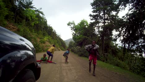 Jóvenes-Africanos-Bailando-Frente-A-Un-Vehículo-Para-Ganar-Dinero-En-El-Valle-De-Omo,-Etiopía