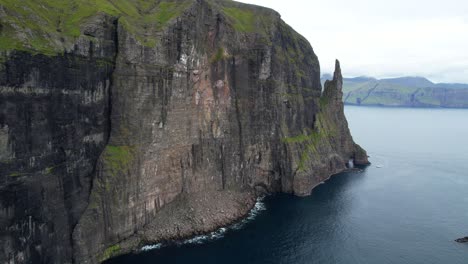 Sheer-shattered-sheet-cliff-erodes-into-Atlantic-Ocean,-green-cliffs-of-Faroese-Vagar-Island