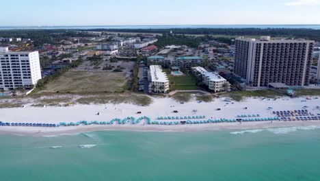 Zoom-out-dolly-aerial-shot-of-beach-resorts-and-hotel-on-Okaloosa-island-in-Destin,-Florida-in-USA