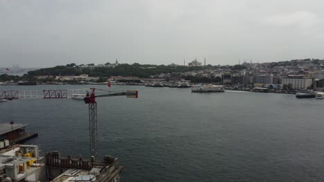 Aerial-drone-footage-of-historic-galata-bridge-in-istanbul-with,-bosphorus,-ships-and-ferries-in-the-background