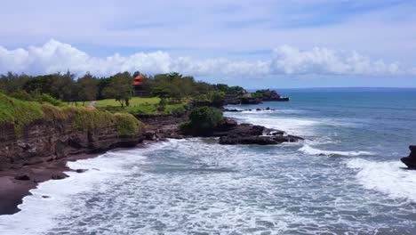 Waves-Coming-To-The-Rocky-Shoreline-Near-The-Tanah-Lot-Temple-In-Summer-In-Bali,-Indonesia
