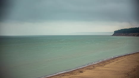 Timelapse-Looking-Out-Over-the-Beach-Shoreline-with-Clouds-Forming-into-a-Mist-of-Rain-on-the-Horizon