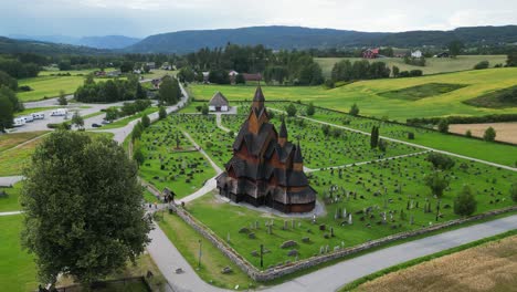 Heddal-Stave-Church-and-Headstones-in-Vestfold-og-Telemark,-Norway,-Scandinavia---Aerial-4k