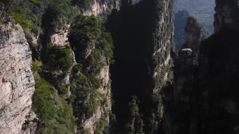 zhangjiajie,-Wulingyuan-Hunan-China-mountain-rock-spires-and-cliffside-vegetation,-aerial-pullback-tilt-up