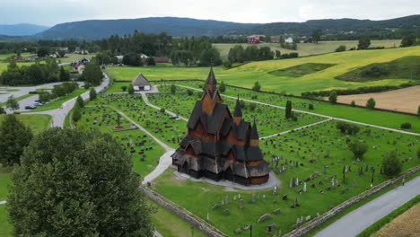 Heddal-Stave-Church-and-Grave-Headstones-in-Vestfold-og-Telemark,-Norway,-Scandinavia---Aerial