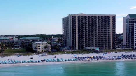 Sundestin-beach-resort-hotel-with-colorful-umbrella-and-beach-chair-in-front-near-Henderson-beach-state-park-in-Destin-Florida-USA