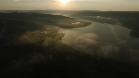 Tilt-up-aerial-over-Lake-Fort-Smith-State-Park-during-mist-laden-summer-sunrise,-Arkansas,-USA