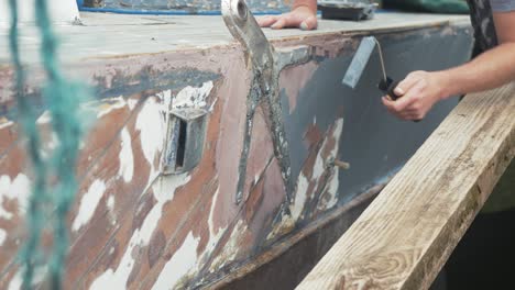 Rolling-grey-primer-onto-hull-of-mahogany-planked-boat