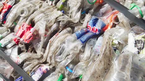 Slow-motion,-closeup-of-a-bale-of-compacted-plastic-bottles-prepared-for-recycling