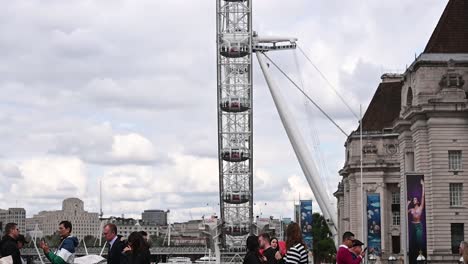 Turistas-Sobre-El-Puente-De-Westminster-Mientras-Observan-El-London-Eye,-Londres,-Reino-Unido