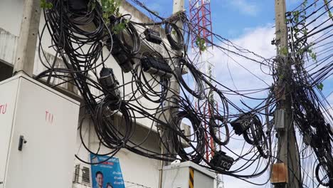 Unordentliche-Elektrische-Leitungen-Und-Telefonkabel-über-Den-Straßen-Der-Stadt-Bangkok,-Thailand