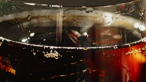 Close-up-of-a-glass-of-cola-with-ice-cubes-floating-in-the-soda