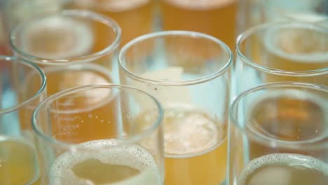 Golden-beer-samples-in-glass-tasters-in-brewery,-closeup,-rack-focus