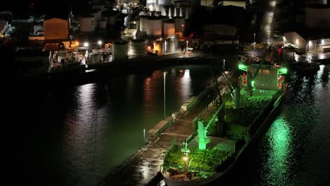 Aerial-night-time-view-of-large-transport-ship-loaded-with-wooden-logs,-Timaru-Port